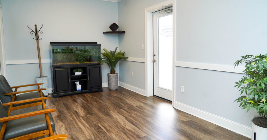 Comfortable waiting area with chairs, plants, and an aquarium at Scenic City Neurotherapy in Chattanooga, TN